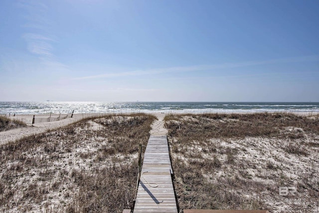 surrounding community featuring a water view and a beach view