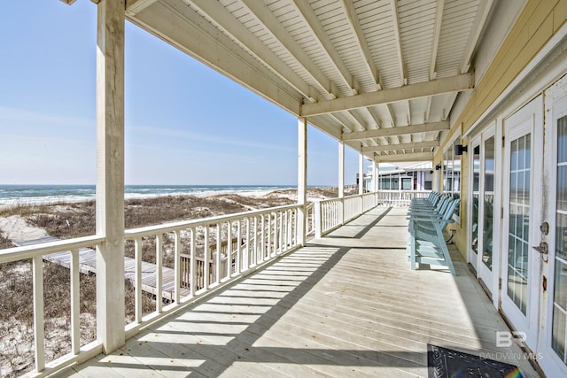 deck featuring a water view and a beach view