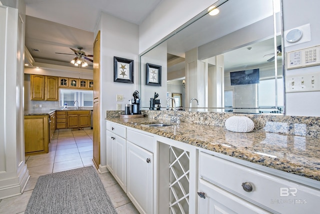 bathroom featuring a ceiling fan, wine cooler, a sink, and tile patterned floors