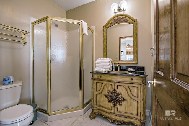 bathroom with toilet, a shower stall, tile patterned flooring, and vanity