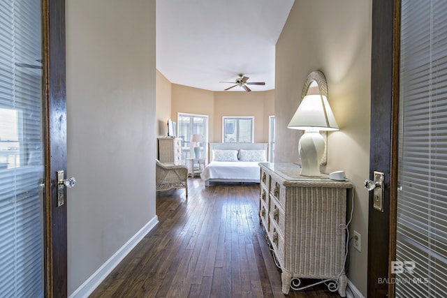 bedroom with baseboards and dark wood-type flooring