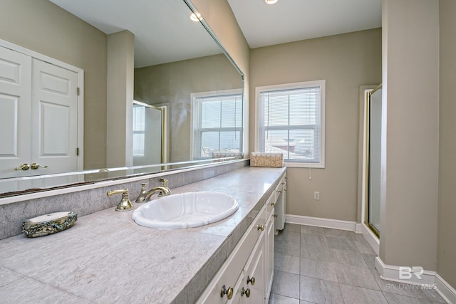 full bathroom featuring a stall shower, tile patterned floors, vanity, and baseboards