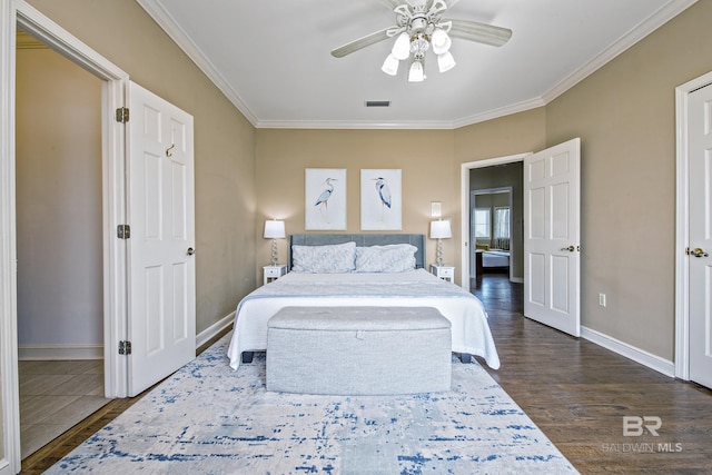 bedroom featuring baseboards, visible vents, dark wood-type flooring, and ornamental molding