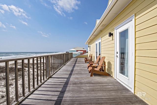 wooden terrace with a water view and a beach view