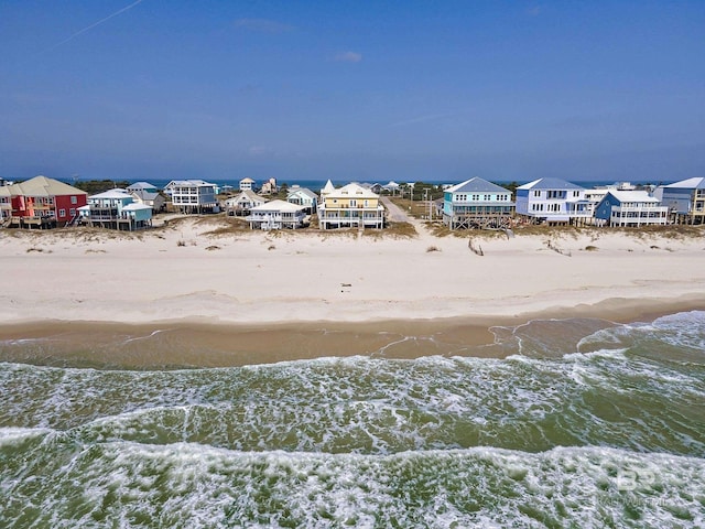 birds eye view of property featuring a water view and a beach view