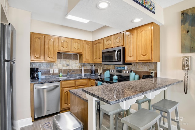 409 E Beach Blvd Unit 184, Gulf Shores, AL 36542 - kitchen with appliances with stainless steel finishes, a sink, a peninsula, decorative backsplash, and baseboards