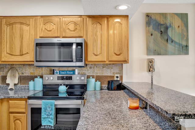 409 E Beach Blvd Unit 184, Gulf Shores, AL 36542 - kitchen with appliances with stainless steel finishes, tasteful backsplash, and light stone counters