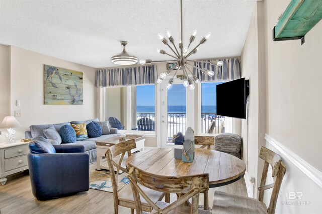 409 E Beach Blvd Unit 184, Gulf Shores, AL 36542 - dining space with a chandelier, light wood finished floors, and a textured ceiling