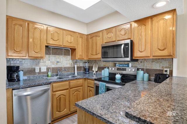 409 E Beach Blvd Unit 184, Gulf Shores, AL 36542 - kitchen with stainless steel appliances, a sink, decorative backsplash, and dark stone countertops