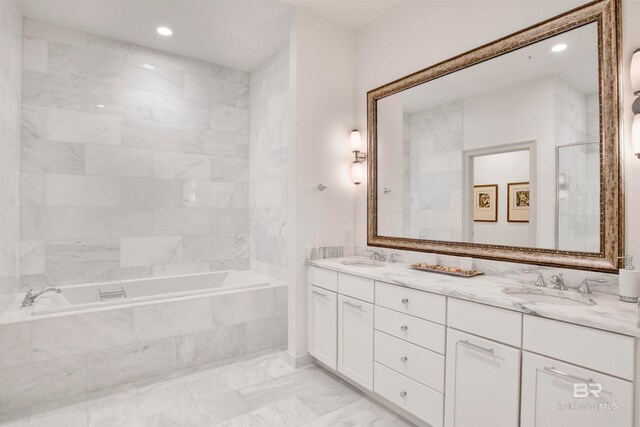 bathroom featuring tiled bath and vanity