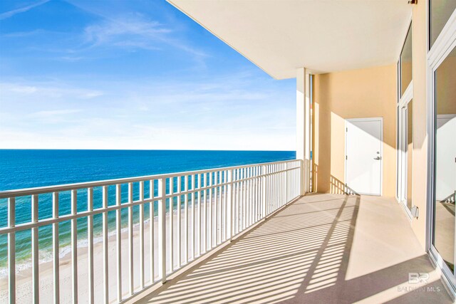 balcony featuring a water view and a beach view