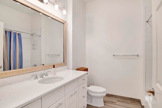 bathroom with vanity, hardwood / wood-style flooring, walk in shower, and toilet