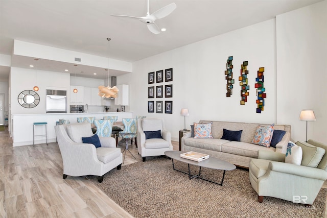 living room with light hardwood / wood-style floors and ceiling fan