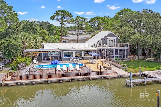 back of property with a water view, a patio area, and a yard