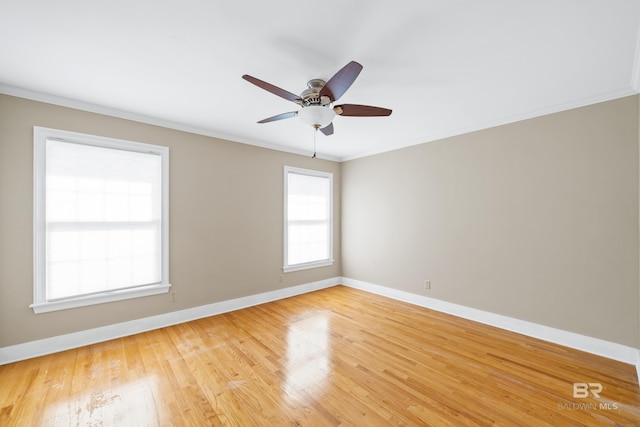 empty room featuring baseboards, ornamental molding, light wood finished floors, and ceiling fan