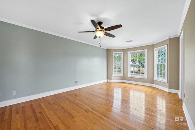 spare room with a ceiling fan, baseboards, ornamental molding, and light wood-type flooring