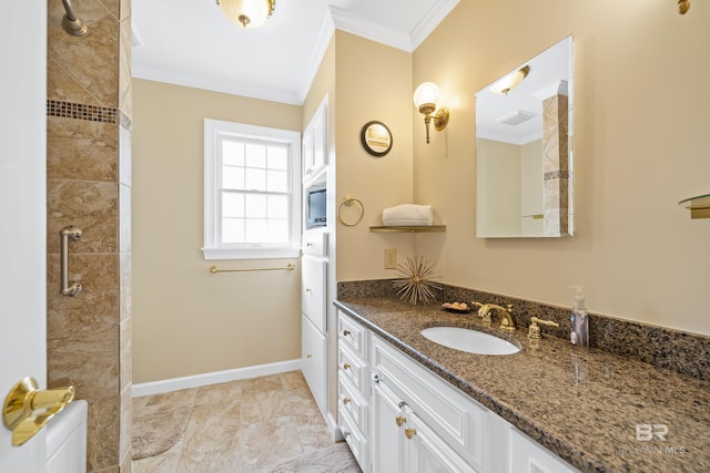 full bathroom with crown molding, baseboards, a tile shower, and vanity