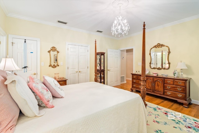 bedroom featuring crown molding, light hardwood / wood-style flooring, and a chandelier