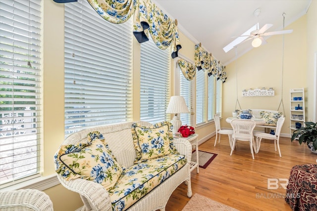 interior space featuring ceiling fan, wood-type flooring, ornamental molding, and vaulted ceiling