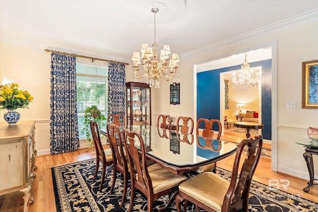 dining area with a chandelier, light hardwood / wood-style floors, and crown molding