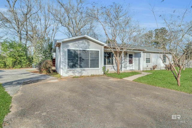 view of front of home featuring aphalt driveway and a front yard