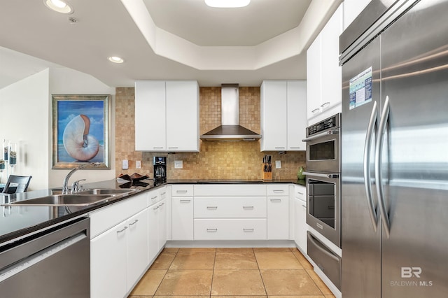 28107 Perdido Beach Blvd Unit D1005, Orange Beach, AL 36561 - kitchen with appliances with stainless steel finishes, wall chimney exhaust hood, a warming drawer, dark countertops, and decorative backsplash