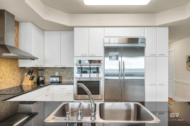 28107 Perdido Beach Blvd Unit D1005, Orange Beach, AL 36561 - kitchen with stainless steel appliances, wall chimney range hood, backsplash, and white cabinets