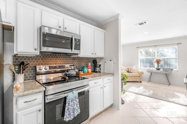 kitchen with white cabinets, light tile patterned flooring, and stainless steel appliances