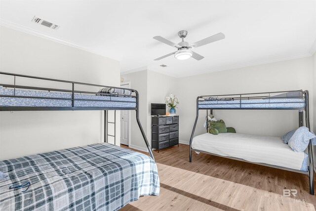 bedroom featuring ceiling fan, ornamental molding, and hardwood / wood-style flooring