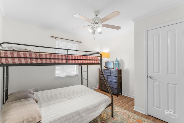 bedroom with light wood-type flooring, ceiling fan, and ornamental molding