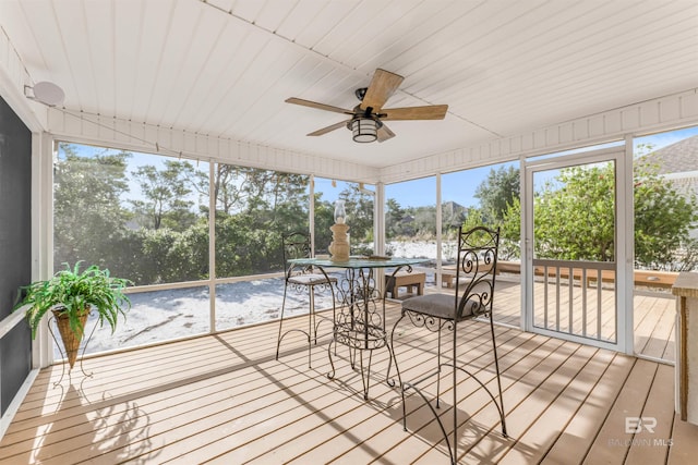 unfurnished sunroom with ceiling fan