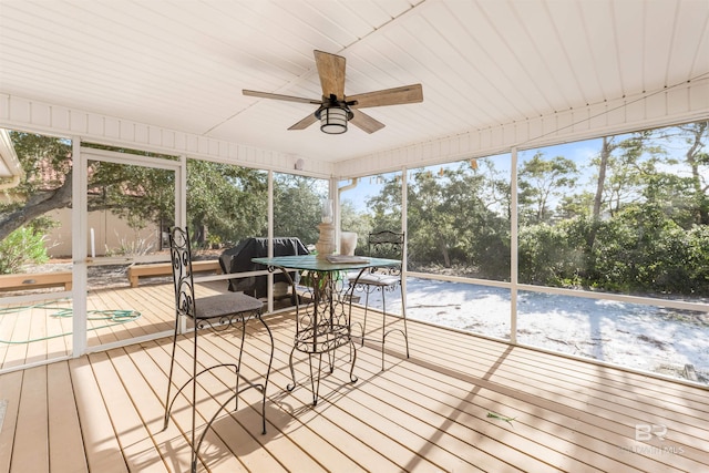 unfurnished sunroom with ceiling fan