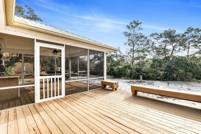 wooden terrace with a sunroom and ceiling fan