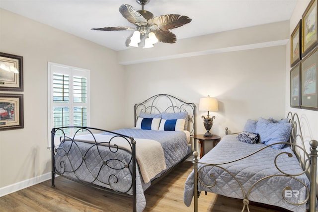 bedroom with wood finished floors, a ceiling fan, and baseboards
