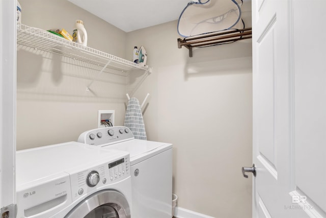washroom featuring laundry area, washing machine and clothes dryer, and baseboards