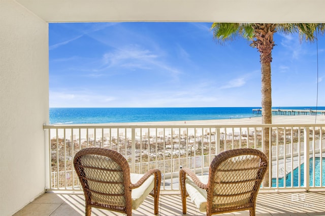 balcony with a water view and a beach view