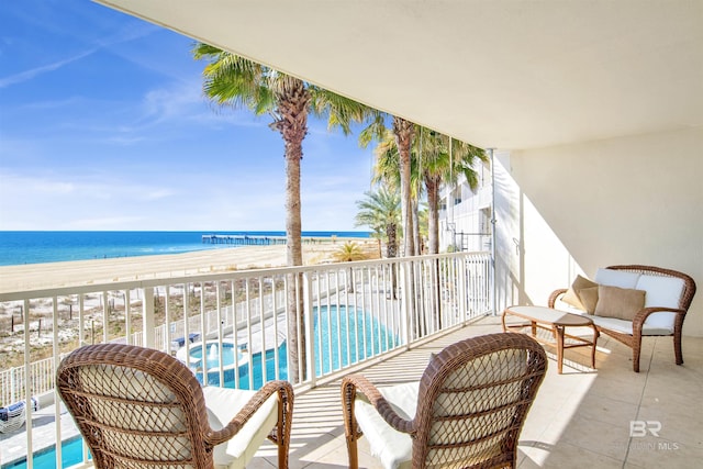 balcony with a water view and a beach view