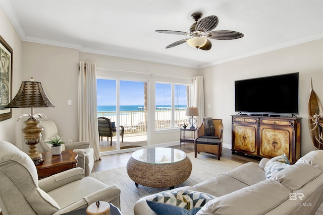living area featuring light wood-style floors, crown molding, baseboards, and ceiling fan