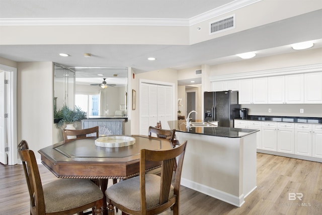 dining room featuring light wood-style flooring, recessed lighting, visible vents, and crown molding