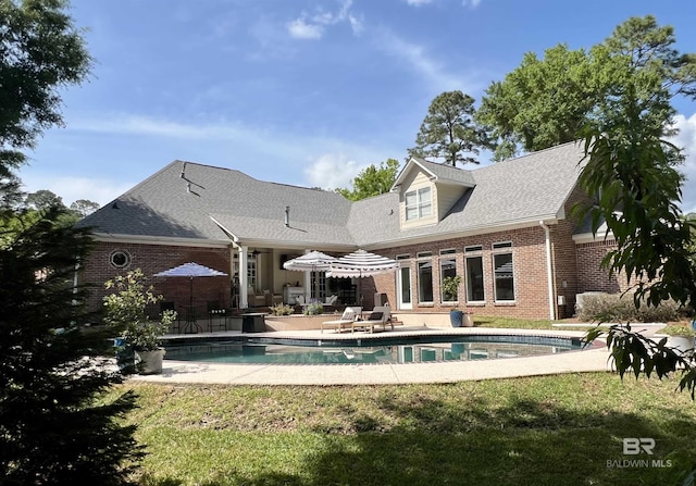 206 N Cir, Fairhope, AL 36532 - rear view of house with brick siding, a patio area, roof with shingles, and an outdoor pool