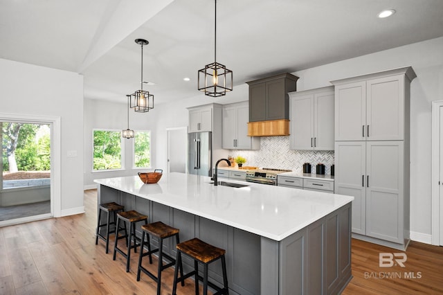 kitchen with appliances with stainless steel finishes, gray cabinetry, and sink