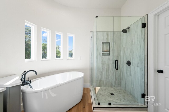 bathroom featuring hardwood / wood-style floors and independent shower and bath