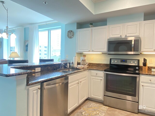 1010 W Beach Blvd Unit 209, Gulf Shores, AL 36542 - kitchen featuring stainless steel appliances, a peninsula, white cabinets, and a sink