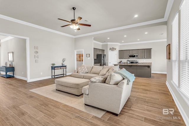 living room with light wood finished floors, visible vents, and ornamental molding