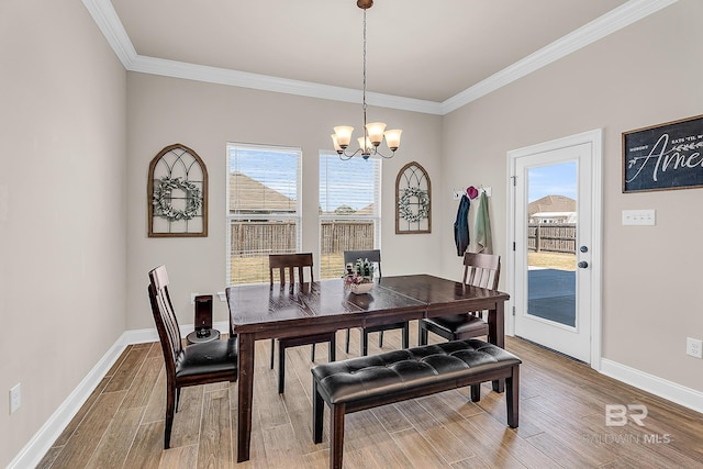dining room with baseboards, a chandelier, wood finished floors, and ornamental molding