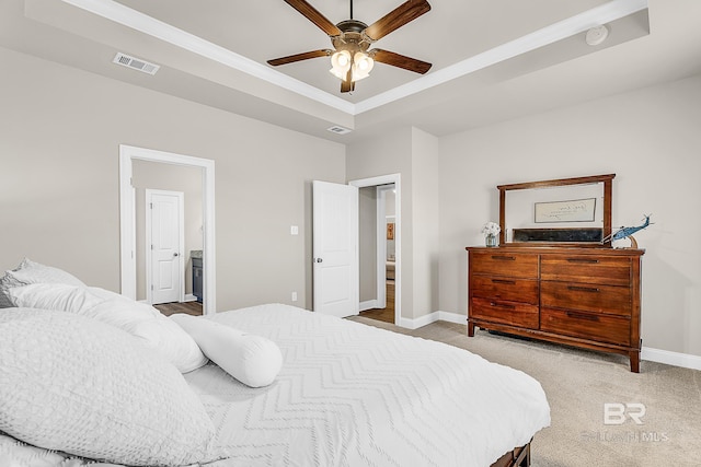 bedroom with carpet, baseboards, visible vents, and a raised ceiling