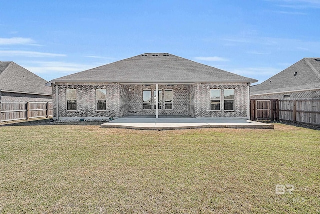 rear view of house featuring brick siding, a fenced backyard, and a patio