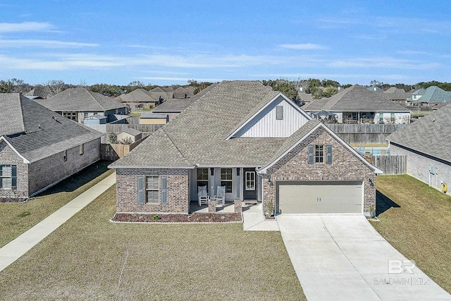 view of front facade with concrete driveway, a residential view, fence, a front lawn, and brick siding