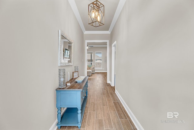 hall with baseboards, ornamental molding, a notable chandelier, and wood tiled floor