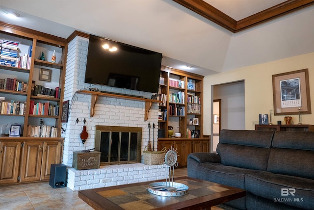 living room featuring built in shelves, crown molding, vaulted ceiling, a brick fireplace, and light tile patterned floors